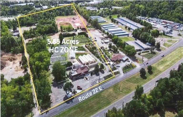 Aerial view of commercial property with industrial buildings, green spaces, and parking areas bordered by Route 22 E